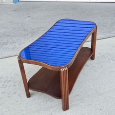 a blue table sitting on top of a sidewalk