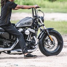 a man with dreadlocks sitting on a motorcycle