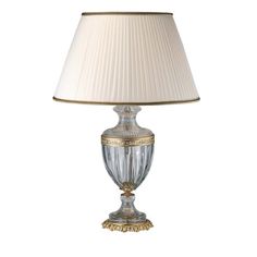 a lamp with a white shade on top of it and a gold trimming around the base