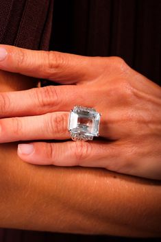 a woman's hand with a ring on it and a diamond in the middle