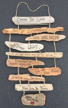 a group of wooden signs hanging on a wall next to each other with words written on them