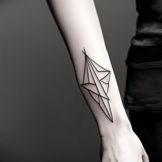 a woman's arm with a black and white origami tattoo on it