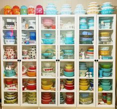 a cabinet filled with lots of colorful dishes