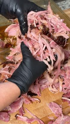 a person in black gloves cutting meat into pieces