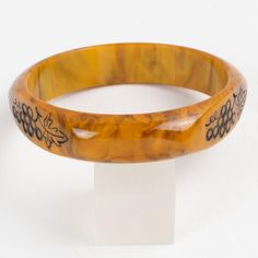 This is part of Chairish’s Costume Jewelry assortment.  Stunning Mississippi swamp marble Bakelite carved bracelet bangle. Domed shape with three flat areas and carved designs. The design features bunches of grapes with black contrast. Intense gold butterscotch marble tone with brown cloudy swirling also called Mississippi swamp color.  Measurements: Inside across is 2.63 in diameter (6.7 cm) - outside across is 3.19 in diameter (8.1 cm) - width is 0.63 in wide (1.6 cm) - Inner circumference is Elegant Tortoiseshell Bangle Jewelry, Elegant Adjustable Carved Bangle, Handmade Bakelite Bangle Bracelet, Elegant Adjustable Tortoiseshell Bracelets, Luxury Carved Bangle Bracelet, Luxury Carved Bangle Bracelets, Elegant Bakelite Bracelet Jewelry, Elegant Bakelite Bracelet, Elegant Bakelite Bangle As Gift