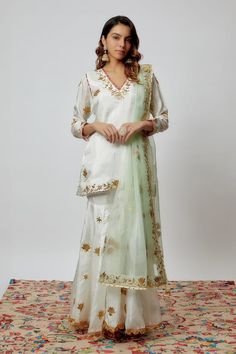 Ivory pure spun silk kurta with gota patti hand embroidery. Comes with sharara and a sea green organza dupatta. - Aza Fashions White Kundan Sets For Designer Wear, Off White Saree Set With Gota Work, White Kundan Lehenga With Cutdana, Festive White Palazzo Set With Gota Work, Off White Sets With Zari Work For Transitional Season, Festive Off-white Gota Work Sets, White Sharara For Wedding And Festivals, Designer White Chinon Dupatta, Off White Sharara With Zari Work And Straight Kurta