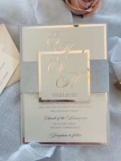 the wedding stationery is laid out on top of the bed with flowers in it