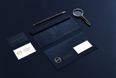 an assortment of stationery items including a magnifying glass, business cards and envelopes