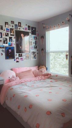 a bedroom with pictures on the wall and pink bedding