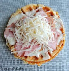 a waffle topped with ham, cheese and grated parmesan