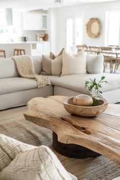 a living room filled with furniture and a wooden table in front of a white couch