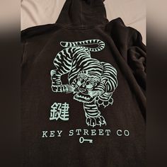 Key Street Co Black Hoodie With Baby Blue Tiger On The Back And On Both Sleeves. Good Condition Only Worn A Handful Of Times, There Are No Damages Or Tears Anywhere. Size Medium, Btw I'm Open To Negotiation I Just Put A High Price Because I Couldn't Find It Anywhere On The Internet So If Anyone Can Send Me A Screenshot Of The Exact Item Being Sold Elsewhere I Will Sell It With The Price They Are Selling It For - 10% On The House However I Don't Think It's Available Anywhere Atm !!!! Blue Tiger, Blue Tigers, On Back, Black Hoodie, Baby Blue, The House, Screen Printing, Mens Shirts, Man Shop