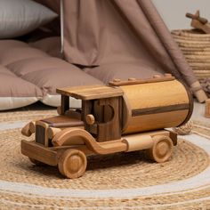 a wooden toy truck sitting on top of a rug