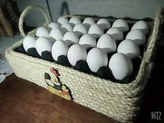 a basket filled with white eggs sitting on top of a wooden table