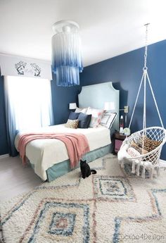 a bedroom with blue walls, white carpet and a hammock hanging from the ceiling