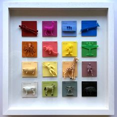 a white frame with many different types of paper animals in it's shadow box