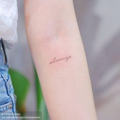 a woman's arm with the word always tattooed on her left arm, in cursive font