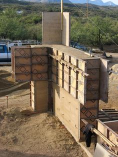 an outdoor kitchen being built in the middle of dirt with mountains in the back ground