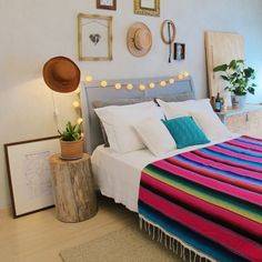 a bed with colorful blankets and pillows on top of it next to a wooden table