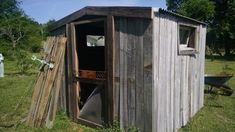 an outhouse in the middle of a field with a door open to reveal another room