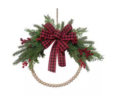 a christmas wreath hanging from the ceiling with red berries and greenery on it's side