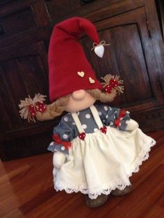 a doll is wearing a red hat and dress