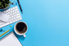 an overhead view of a desk with a keyboard, mouse and coffee cup on it