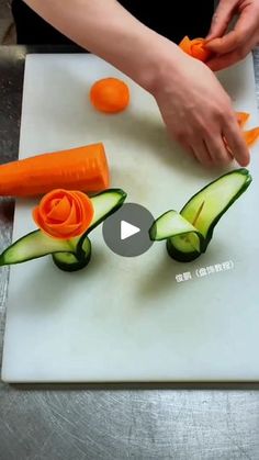 someone cutting cucumbers and carrots on a cutting board