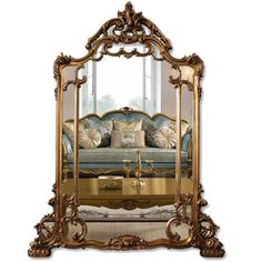 an ornate gold framed mirror with couch in the reflection