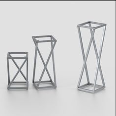 three different types of metal structures on a white surface, one is standing up and the other is sitting down