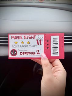 someone holding up a movie ticket for deadpool 2 in front of their car door