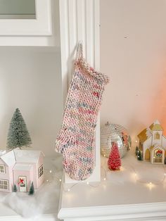 a christmas stocking hanging from the side of a fireplace with other decorations around it