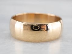 This simple wedding band is made special due to the quality of the metal! Crafted of 18 karat gold, this ring has a rich hue and fantastic polish that feels luxurious. The generous width and subtle dome make this band perfect for larger hands. Metal: 18K Yellow Gold Width of Band: 7.7 mm Height off Finger: 1.4 mm Ring Size: 10 Marks: "18" Stamped on the inside band Mens Wedding Bands Vintage, Simple Wedding Band, 10 Marks, Wedding Band Vintage, Mens Wedding Ring, Simple Wedding Bands, Mens Gold Wedding Band, Vintage Wedding Band, Men's Wedding Ring