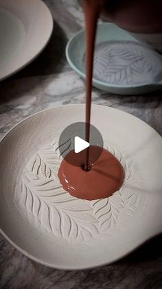 a person pouring chocolate into a white plate