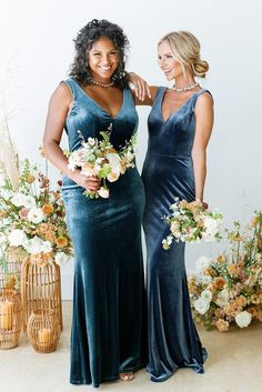 two women standing next to each other in dresses