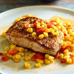 a white plate topped with meat covered in corn