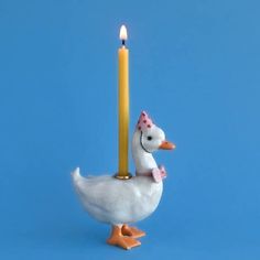 a white duck with a candle in it's beak