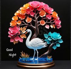 a statue of a flamingo standing in front of a tree with roses on it