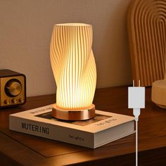 a lamp that is sitting on top of a book next to a speaker and other items