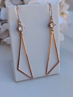 Rose Gold Toned Triangle Earrings w/ CZ Silver Plated Connector,  Geometric Drop Boho Earrings,  Large Statement, Laser Cut, Trillion Shaped These stainless steel earrings have a modern vibe and simplistic design. They're lightweight and fun, perfect for adding detail and intrigue to any outfit. The earrings are hung from rose gold-plated sloped ear wires. The base metal is brass, nickel-free, and lead-free. The ear wires are hammered with smooth ends and 21 gauge. They measure 25mm X 10mm. Rose Triangle Earrings, Design Simple, Stainless Steel Earrings, Style Moderne, Boho Earrings, Ear Wires, Rose Gold Plates, Or Rose, Jewelry Earrings Dangle