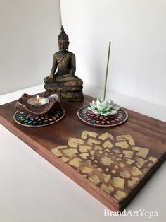 a buddha statue sitting on top of a wooden tray