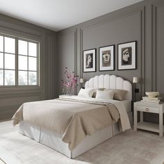 a bedroom with gray walls and white bedding in the center, along with two framed pictures on the wall