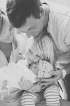 a man and two women are holding a baby