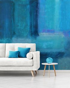 a living room scene with focus on the sofa and blue wallpaper that has been painted