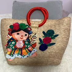 a handbag with an embroidered doll on it