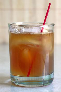 a close up of a drink in a glass on a table with a straw sticking out of it