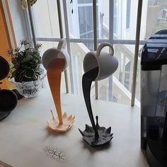 two vases sitting on top of a counter next to a coffee maker and window