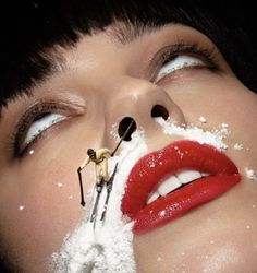 a woman with snow on her face and skis sticking out of her mouth