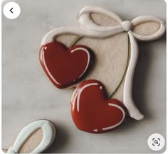 two decorated cookies with red and white icing in the shape of heart shaped cookie cutters