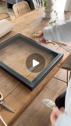 a person is working on an art project with scissors and wood planks at a table